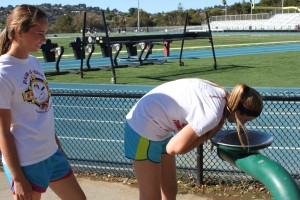 Without water bottles, freshmen Sydney Adair (left) and Isabel Peate (right) make a trip to the water fountain to stay hydrated at girls' basketball conditioning. 