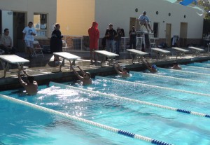 Carlmont and Burlingame swimmers prepare at the wall before a 100 meter backstroke.