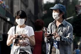 Tourists arrive at circuit wearing face-masks after a recent outbreak of the bird flu virus