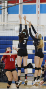 Erin Alonso and Lauren Tierney jump for a block