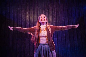 Finishing a musical number,  Cristina Oeschger smiles as the audience applauds. 