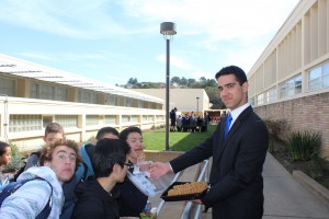 Senior class president candidate Omid Afshar serving cookies to potential voters before they head to the voting booths.